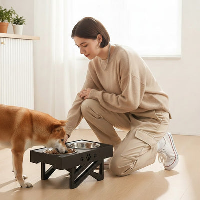 FURRYKU black elevated dog feeder with two stainless steel bowls, featuring paw print cutouts. Ergonomic design for joint support.